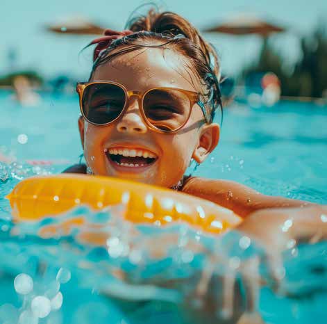 Criança sorrindo na piscina aproveitando o lazer com a família