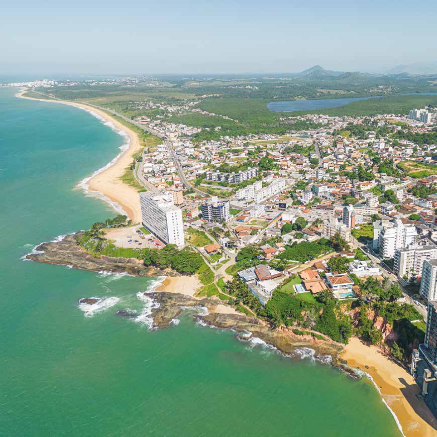 Vista aérea da orla, praia e região urbana próxima ao empreendimento